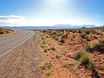 Road amidst desert against sky