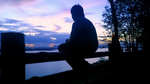 Silhouette of woman against cloudy sky