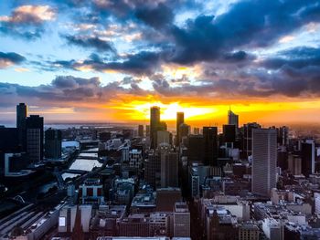 Aerial view of modern buildings against sky during sunset