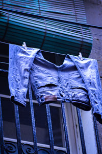 Low angle view of clothes drying against blue window