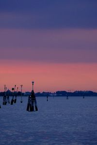 Silhouette sailboats in sea against sky during sunset