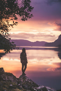 Silhouette man standing on mountain against sky during sunset