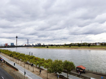 High angle view of factory by river against sky