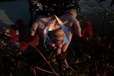 Cropped image of woman holding prism while standing outdoors