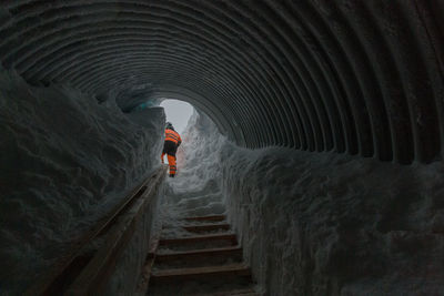 Walking up stairs and out of a cave tunnel under a glacier of ice