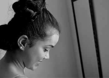 Smiling woman with hair bun at home