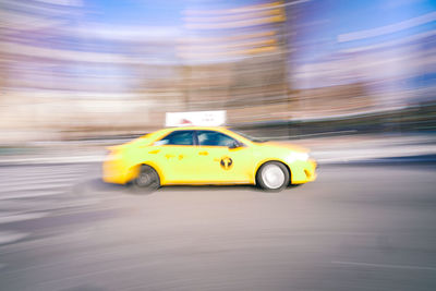 Yellow toy car on road in city