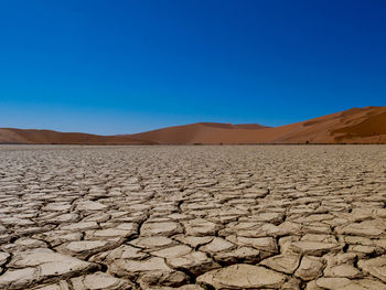 Scenic view of desert against clear blue sky