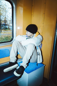 Contemplative boy looking through window while sitting in tram