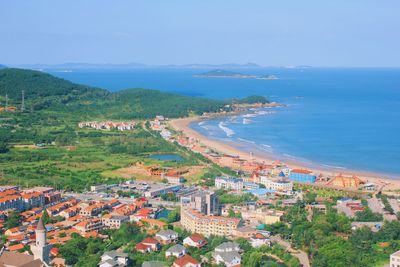 High angle view of townscape by sea against sky