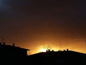 Silhouette buildings against sky during sunset