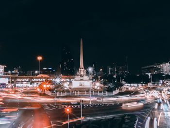 Light trails on street amidst buildings in city at night
