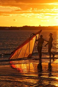 Couple at beach going for windsurfing