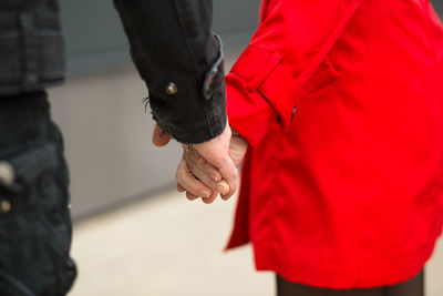 Midsection of woman with red standing against blurred background