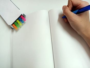 Cropped image of hand holding book on table