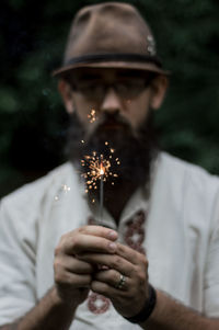 Close-up of man holding sparkler