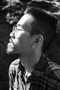 Close-up of young man wearing eyeglasses looking away