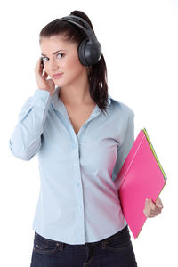 Young woman looking away while standing against white background
