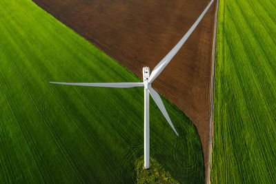 Aerial view of wind turbines farm on agricultural field in summer