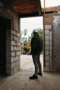 Foreman builder engineer worker looking at large building construction site sunny day hard work