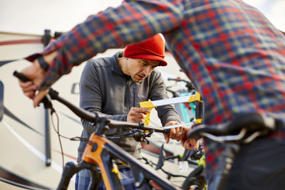 Mountain bikers working together to cut down handlebars.