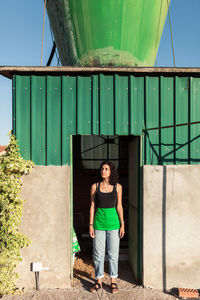 Portrait of woman standing against built structure