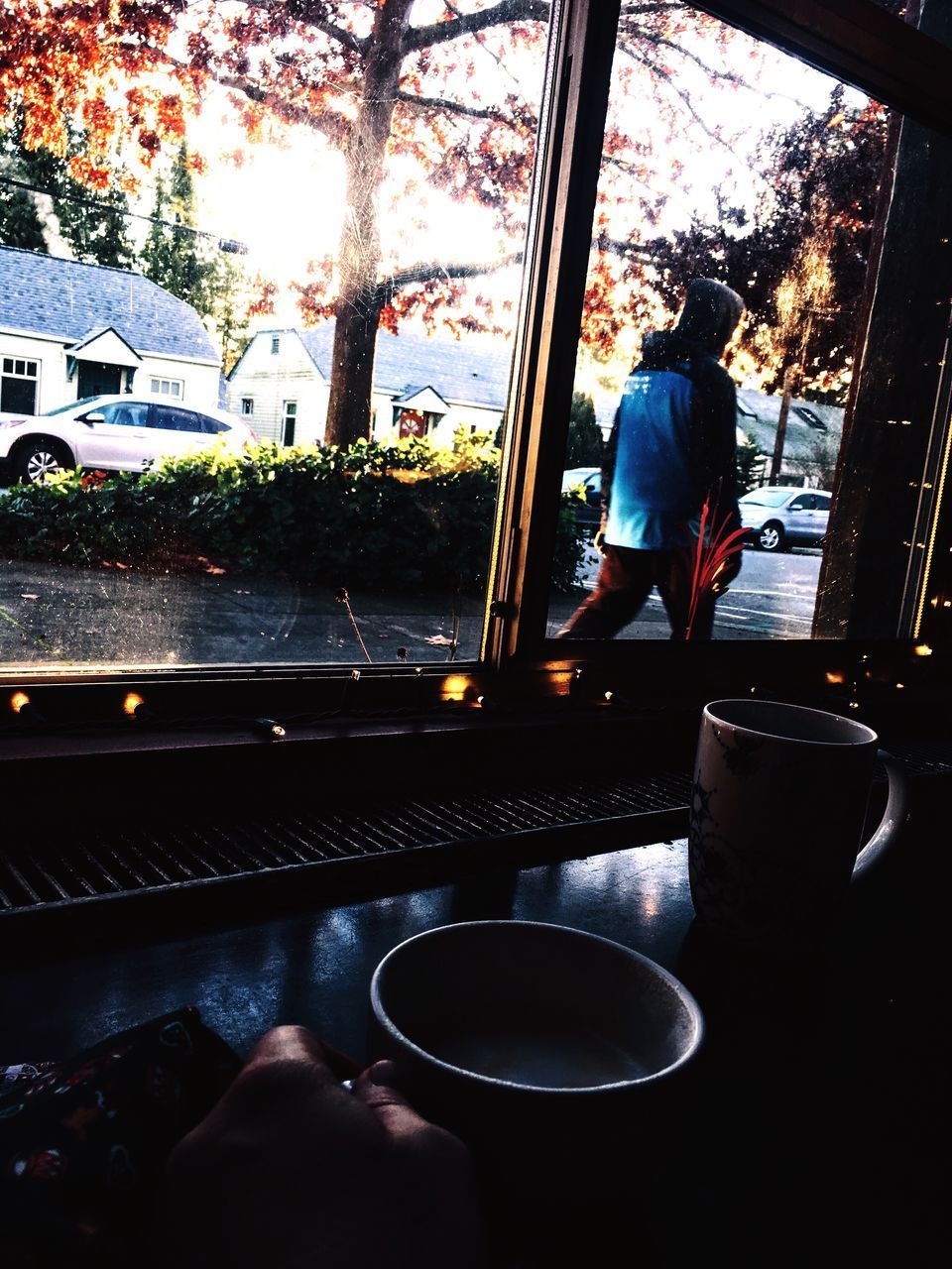 REAR VIEW OF MAN STANDING BY WINDOW