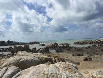 Scenic view of rocks on beach against sky