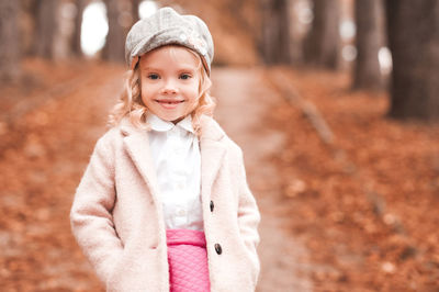 Cute girl wearing cap standing in park