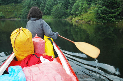 Rear view of woman boating on lake