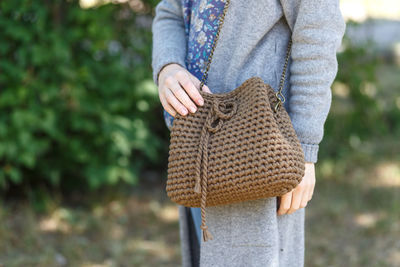 Midsection of woman carrying purse