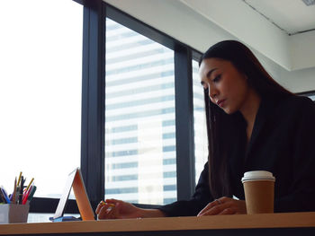 Woman working with coffee cup on table