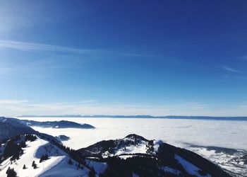 Scenic view of snowcapped mountains against blue sky