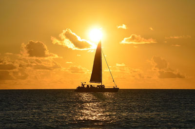 Silhouette sailboat on sea against sky during sunset