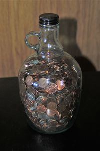 Coins in glass bottle on table