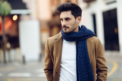 Young man walking on road in city