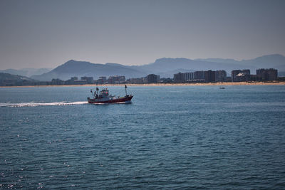 Boat sailing in sea against sky