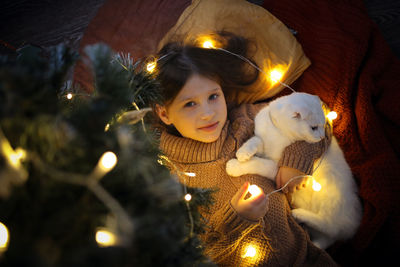 Cat and a girl under the christmas tree in a christmas atmosphere, the concept of christmas 