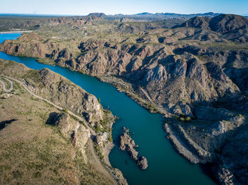 Scenic view of river by mountains against sky