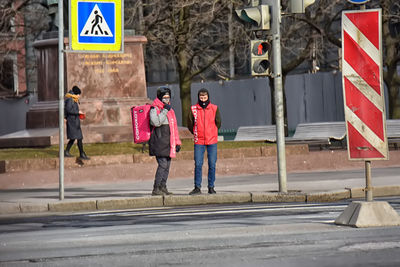 Rear view of people walking on road