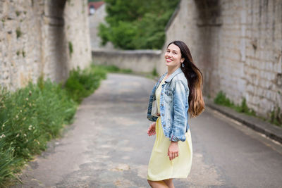 Lifestyle portrait of young stylish woman walking on the street