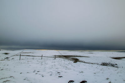 Scenic view of snow covered field against sky