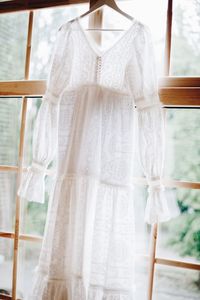 Wedding dress hanging by window at home