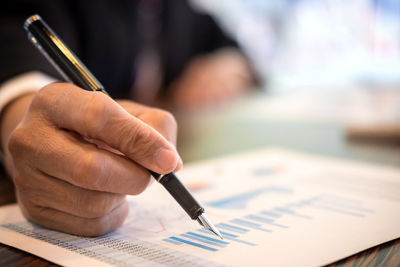 Cropped image of businessman writing on graph paper