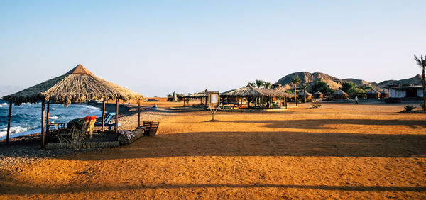 Scenic view of beach by sea against clear sky