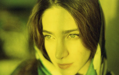 Close-up of young woman looking away while standing outdoors