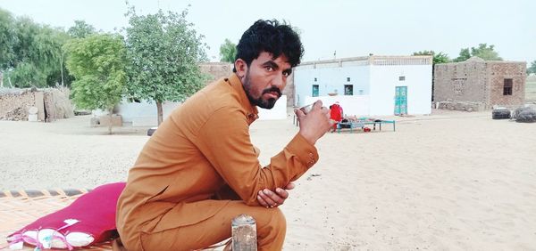 Portrait of young man sitting on beach