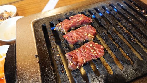 High angle view of meat on barbecue grill