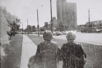 Two womens walking together,  and branches background