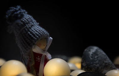 Close-up of easter egg in doll shape against black background